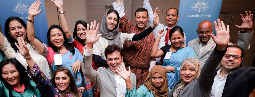 Regional Alumni Workshop participants raise their hands for a group photo