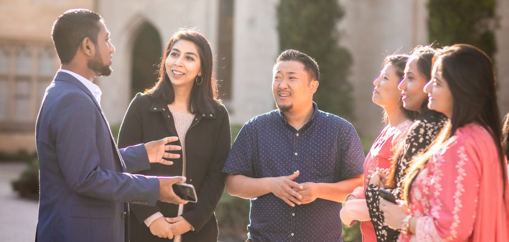 Scholars network outdoors on a university campus