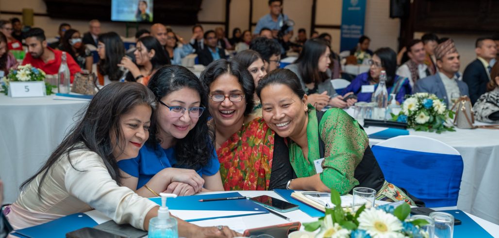 Participants collaborate around a tablet during the Regional Alumni Workshop