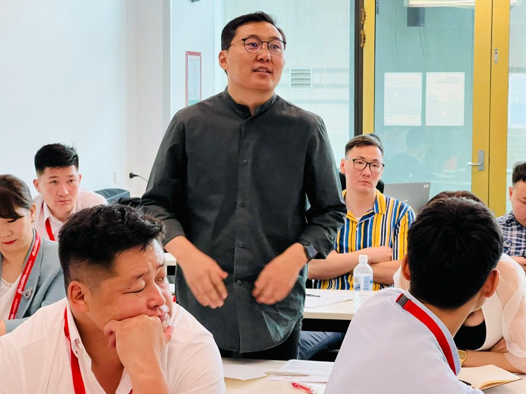 Ireedui (sitting behind the participant standing) participating in the Short Course lessons.