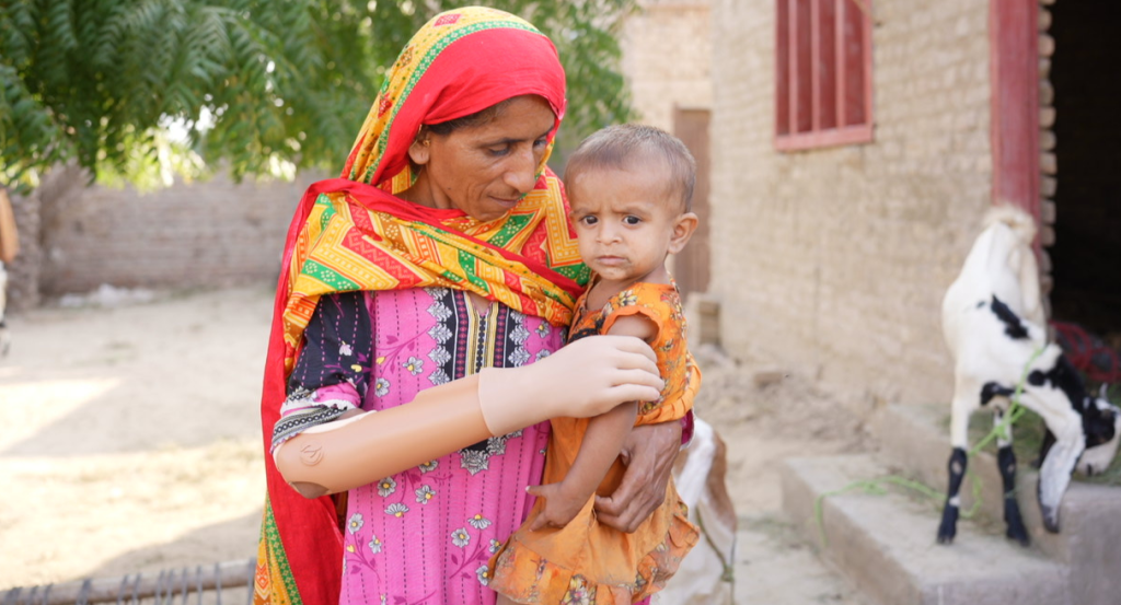 A hand restored: Habiba holding her child after receiving her AI-powered prosthetic limb