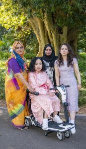 Four women, including a wheelchair user, together in a park