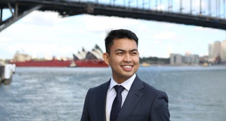Wan Nie standing by Sydney Harbour Bridge and the Opera House