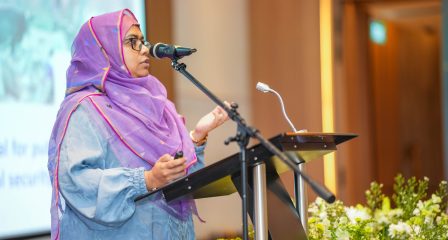 Alumna speaking at a lectern