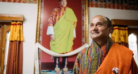 Loknath Sharma in front of a portrait of the King of Bhutan
